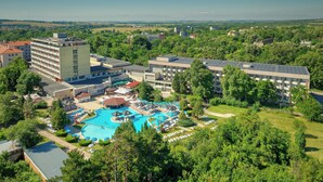 A hotel with multiple buildings, a swimming pool, and surrounding greenery. - Augusta SPA hotel (Hisarja)