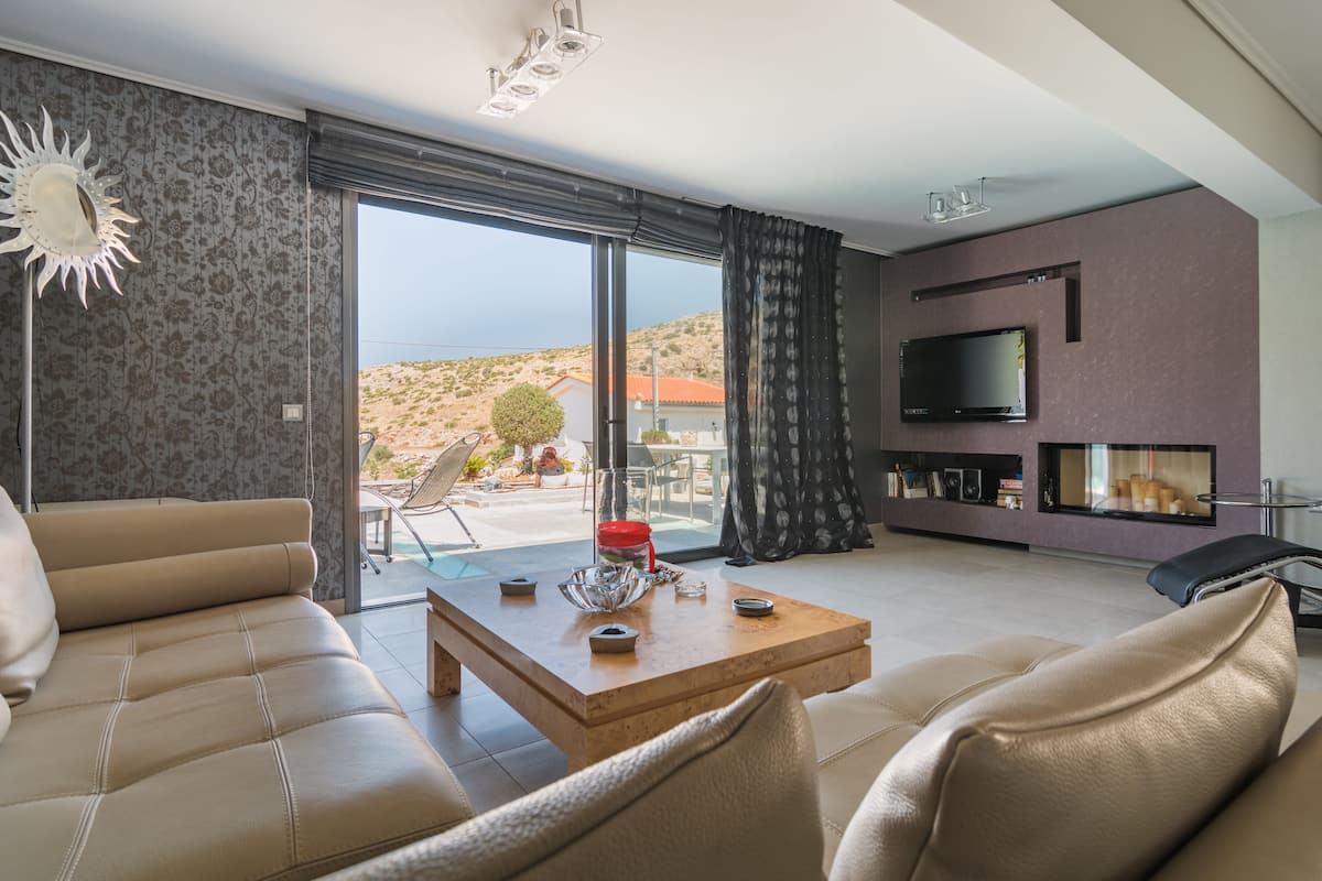 Una sala de estar moderna con un sofá, una mesa de centro y un televisor montado en la pared.