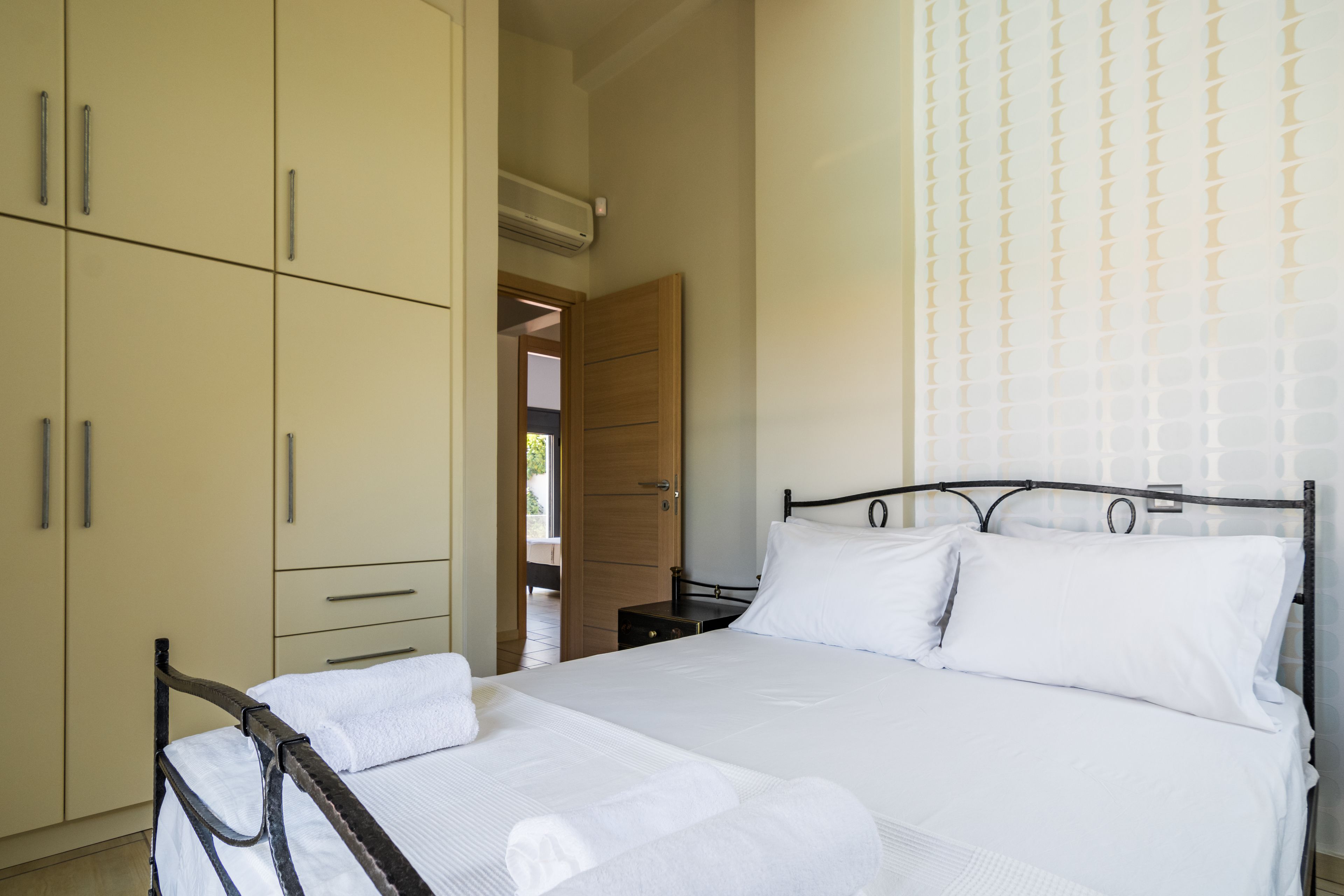 Un dormitorio con cama, armario y puerta que da a otra habitación.