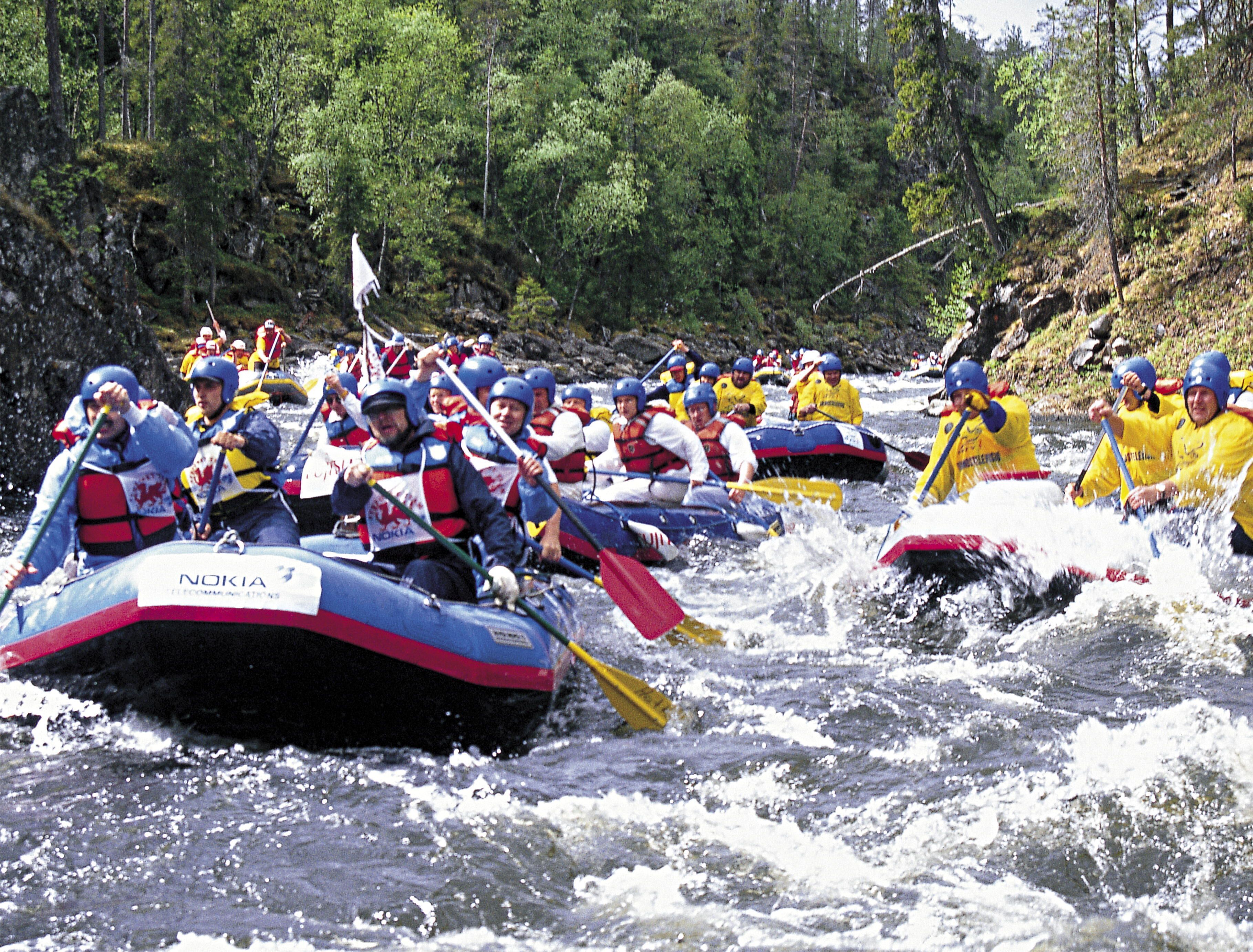 A group of people in inflatable rafts navigating a river.