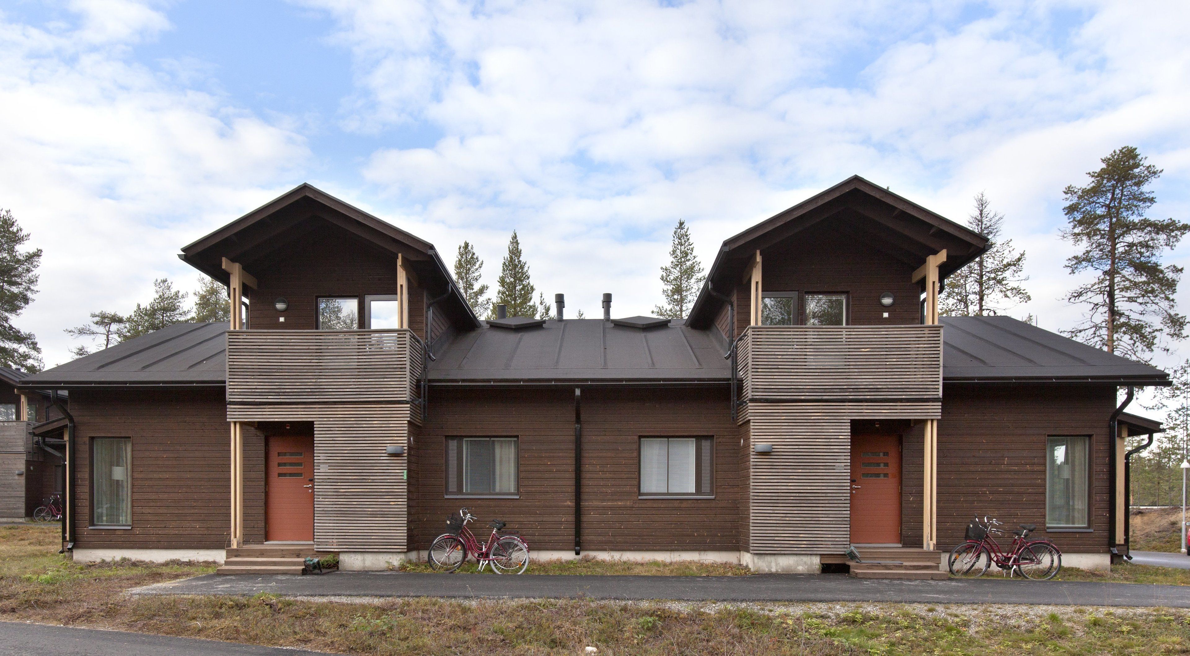 Un bâtiment moderne à deux étages, doté d’une conception symétrique, avec une entrée centrale flanquée de deux balcons.