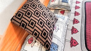 A bed with patterned pillows and a bedspread with floral and geometric designs. - Hotel Alas Garden (Trincomalee)