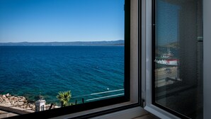 A view from a window overlooking a body of water with distant land. - Luxury Seaside Apartments (Bol)