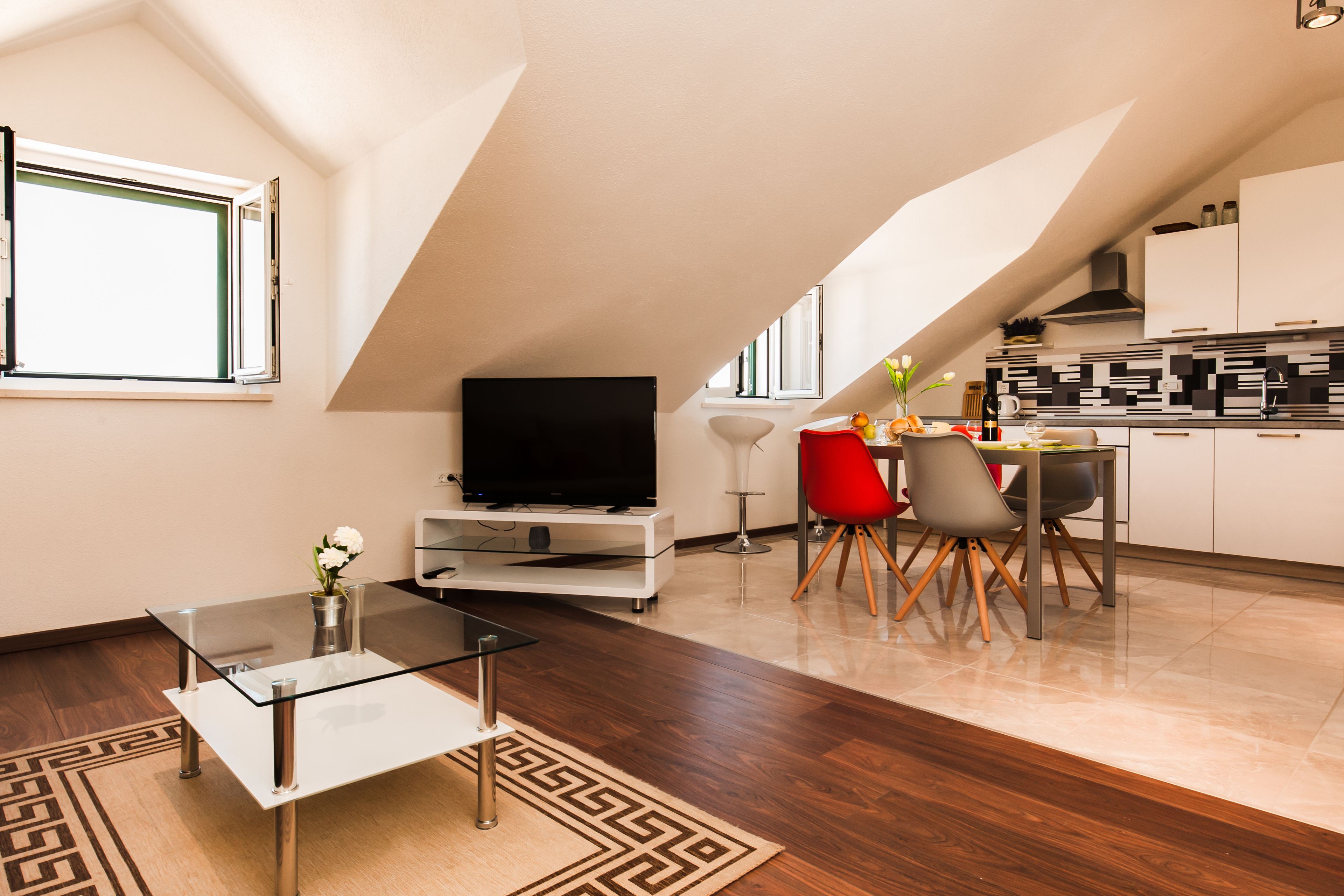 A modern loft apartment with a dining area, kitchen, and living space.