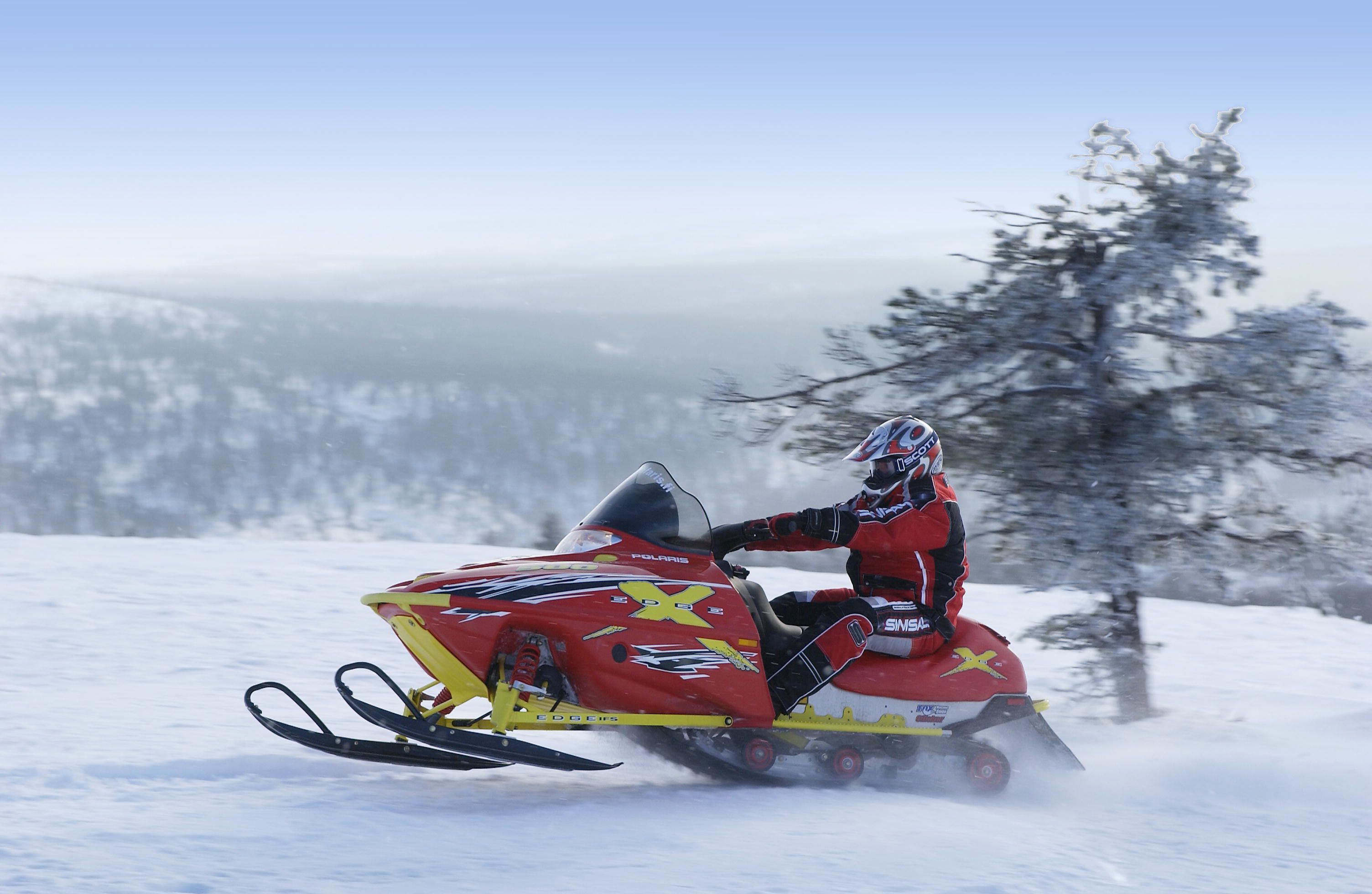 Motocicleta de nieve con un conductor en un paisaje nevado.