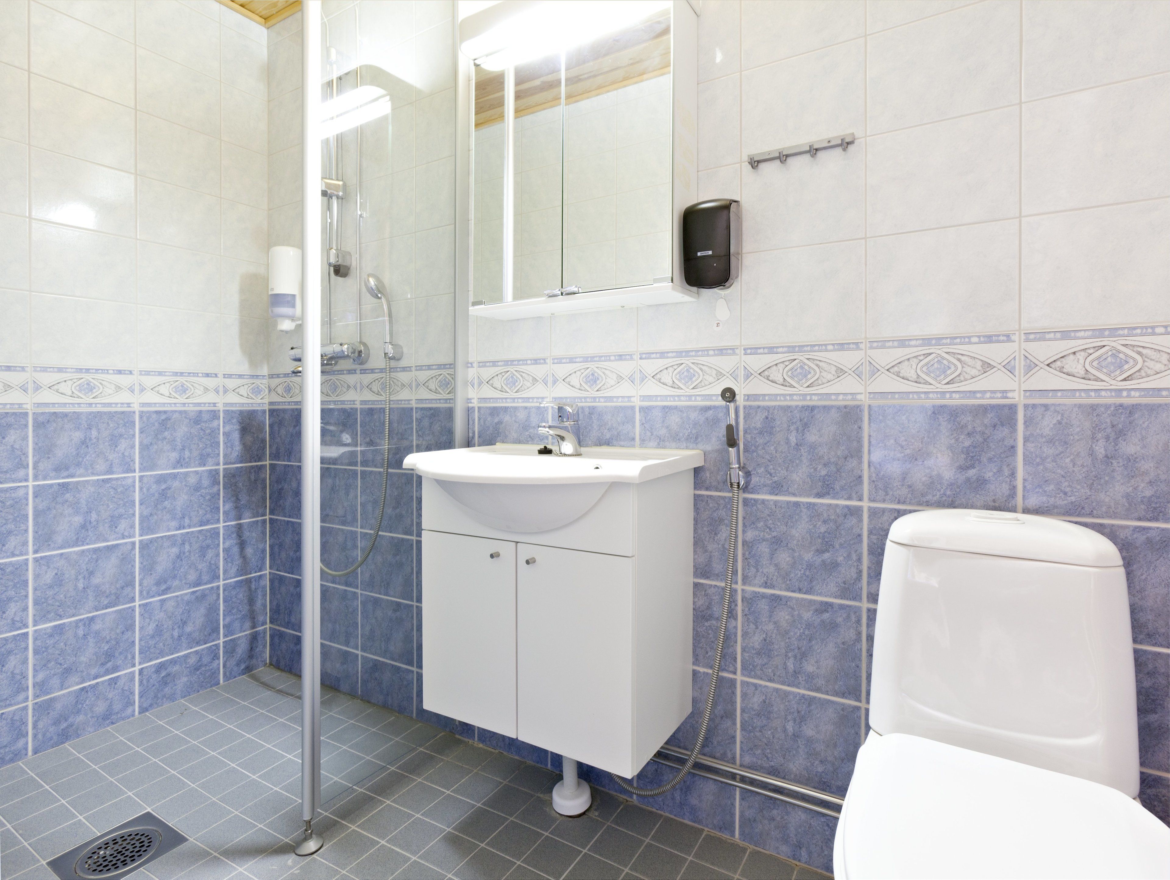 A bathroom with a shower, sink, and toilet.