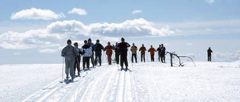 A group of people standing on a snowy slope with a clear sky.