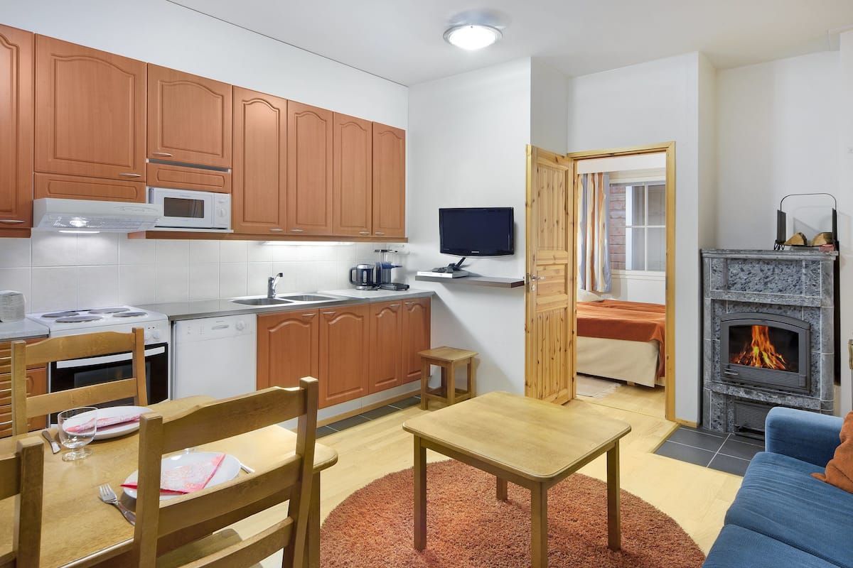 A compact living space with a kitchen, dining area, and a fireplace.