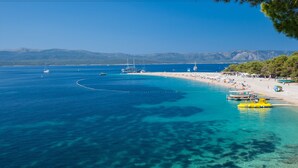 A coastal beach with clear blue waters, boats, and a sandy shore. - Mazuranic Apartments (Bol)