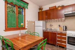 Una cocina con armarios de madera, un refrigerador blanco, una estufa y un lavabo.