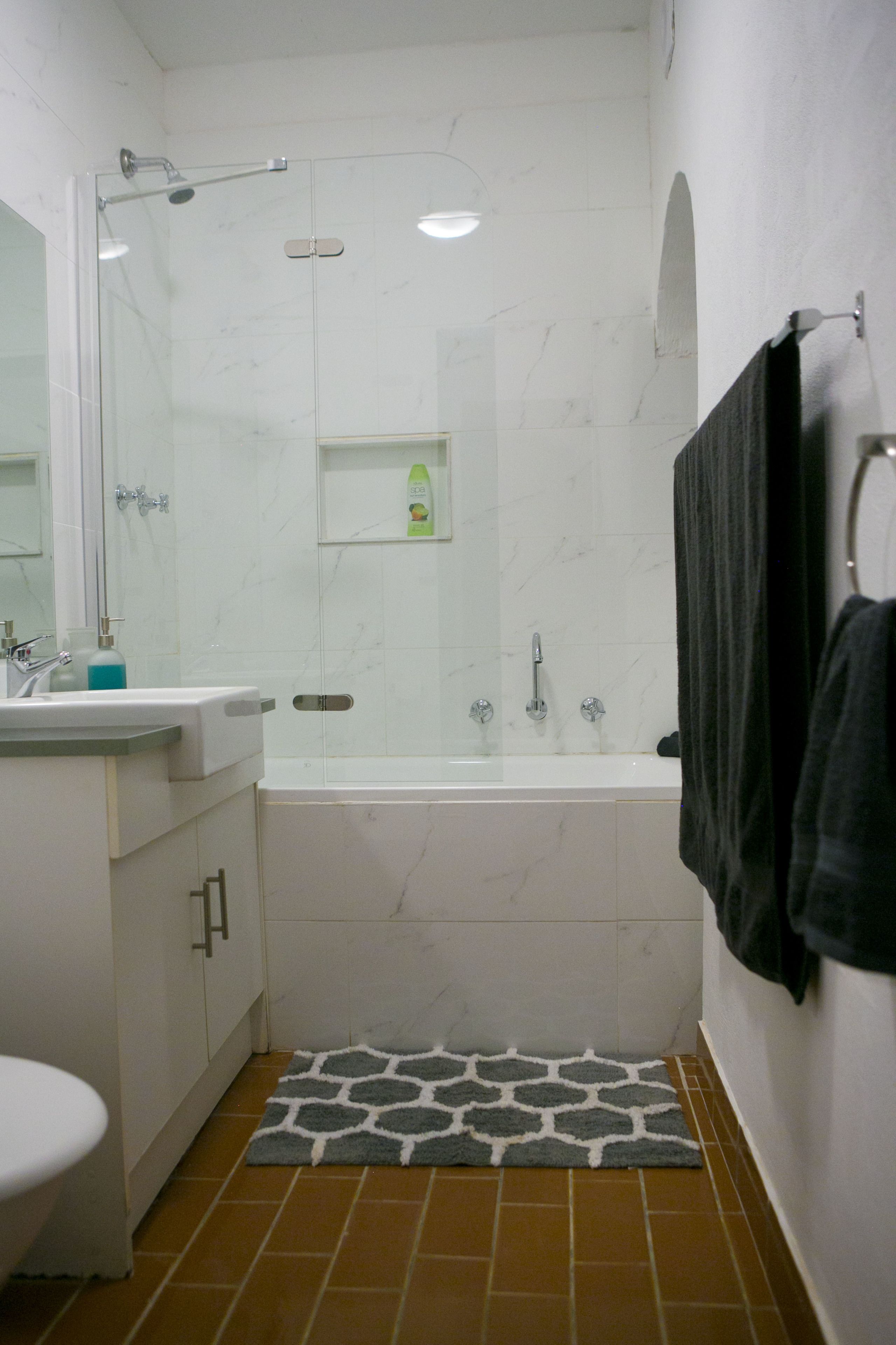 Une salle de bain avec douche, toilettes et lavabo.