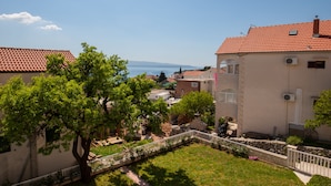 Un barrio residencial con casas, un patio arbolado y vistas al mar.