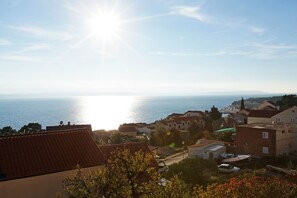 A coastal town with buildings, a clear sky, and the sea in the background. - Rose Garden Apartments (Bol)