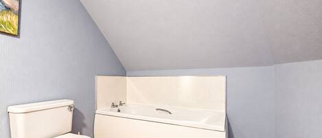 A bathroom with a toilet, a bathtub, and a sink.
