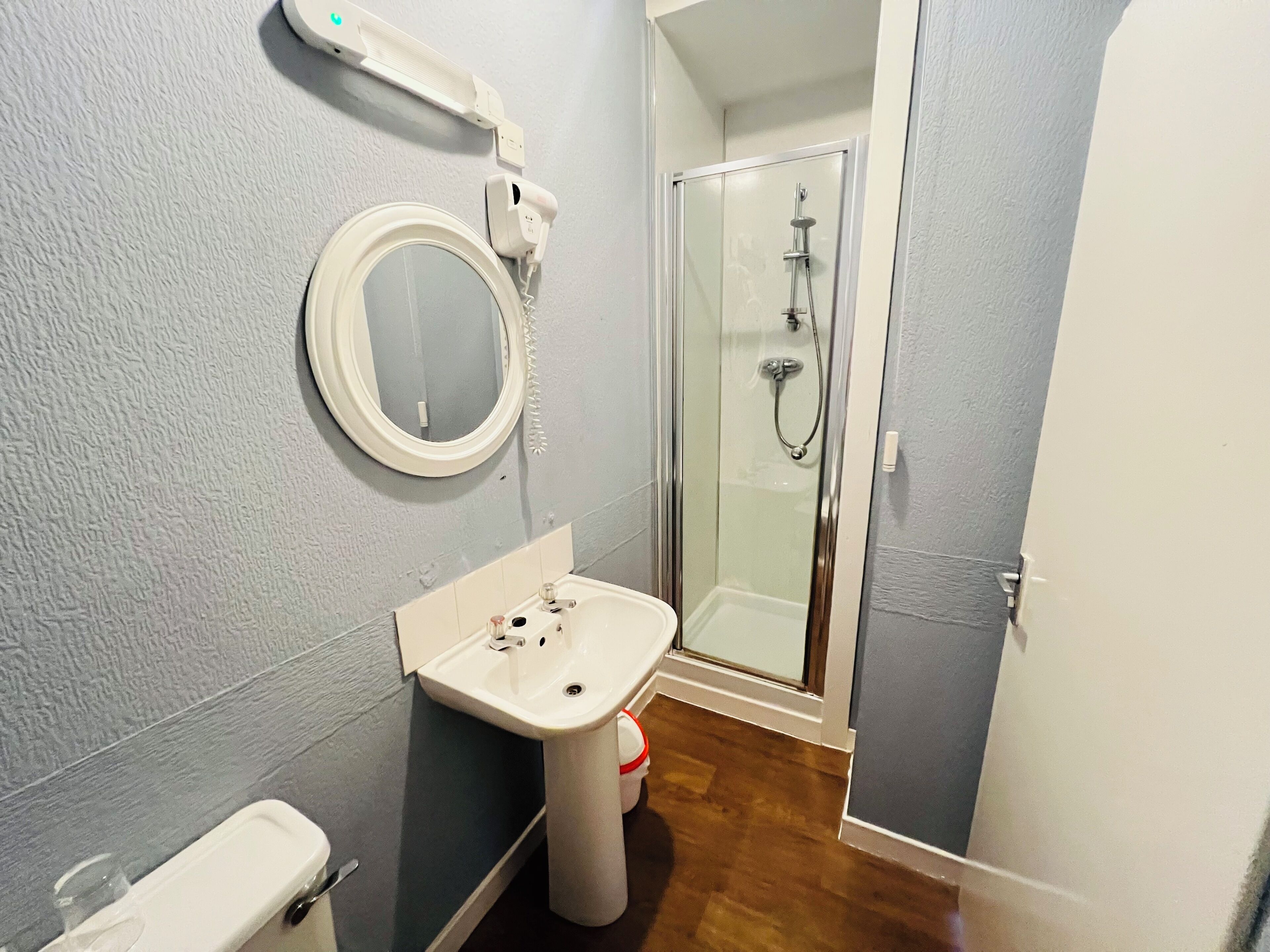 Une salle de bain avec un lavabo, un miroir et une douche.