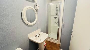 Une salle de bain avec un lavabo, un miroir et une douche.