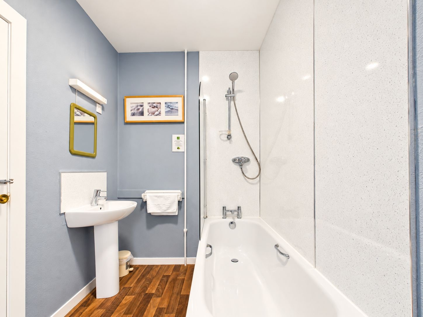 A bathroom with a bathtub, sink, and shower.