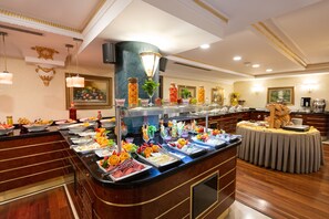 A buffet with various food items and a decorative centerpiece. - Ilci Residence Hotel (Ankara)
