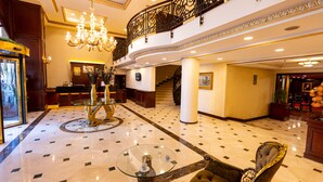 A grand lobby with a chandelier, a glass table with a vase, and a plush armchair. - Ilci Residence Hotel (Ankara)