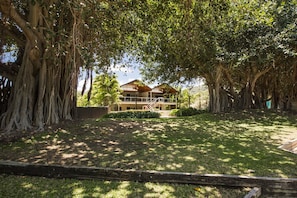 Overlooking a tranquil courtyard with a tree-lined garden, this hotel features a traditional architectural style and a balcony with a grassy area below.