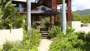 A multi-story building with a staircase leading to a covered area. - Lotus House (Horseshoe Bay)