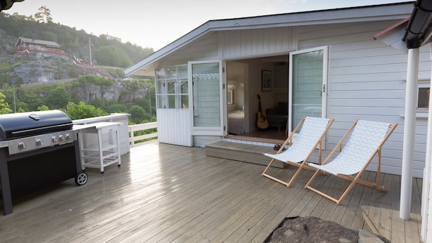 A wooden deck with a grill, two folding chairs, and a guitar leaning against the house. - Soltvedts Cabin - Bjønnes (Porsgrunn)