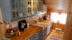 A compact kitchen with wooden cabinets, a sink, and a small dining area.