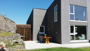 A modern two-story house with a large window and a patio area. - Haver Cabin - Sirevåg (Ha)