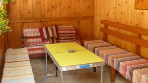A wooden cabin interior with a long table, benches, and a bed. - Apartments Majercak (Zuberec)