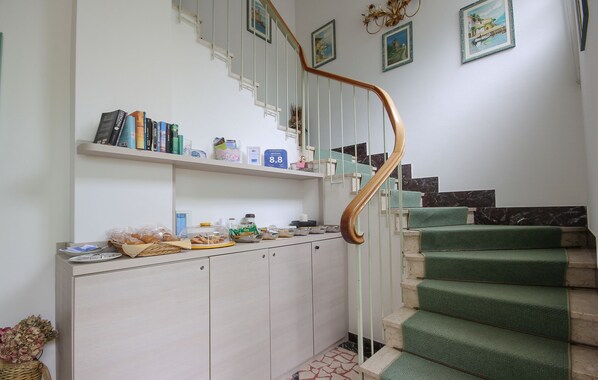 Una escalera con peldaños cubiertos de moqueta verde y barandilla de madera.