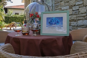 Ein Tisch mit einer Flasche Alkohol, einem Glas und einem gerahmten Bild.