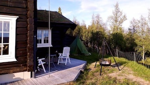 A wooden cabin with a porch, outdoor seating, and a swing set. - Blazerbu - Cabin for 8 persons - Hol (Hol)