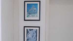 A white door with two framed artworks above it. - Apartamento 2 dorms Metrô Saúde (São Paulo)