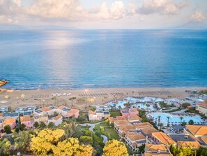 Une station balnéaire dotée de villas en bord de mer, d’une piscine et d’une plage.