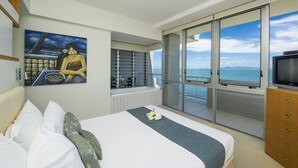 Een hotelkamer met een bed, een schilderij, een badkamer met een badkuip en een televisie.