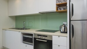 Een moderne keuken met een magnetron, oven en roestvrijstalen apparatuur.