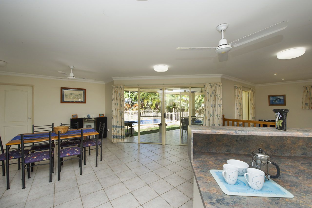 A spacious dining area with a table and chairs, a coffee station, and a view of the outdoors.