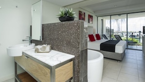 A modern bathroom with a marble vanity, a large mirror, and a shower area.