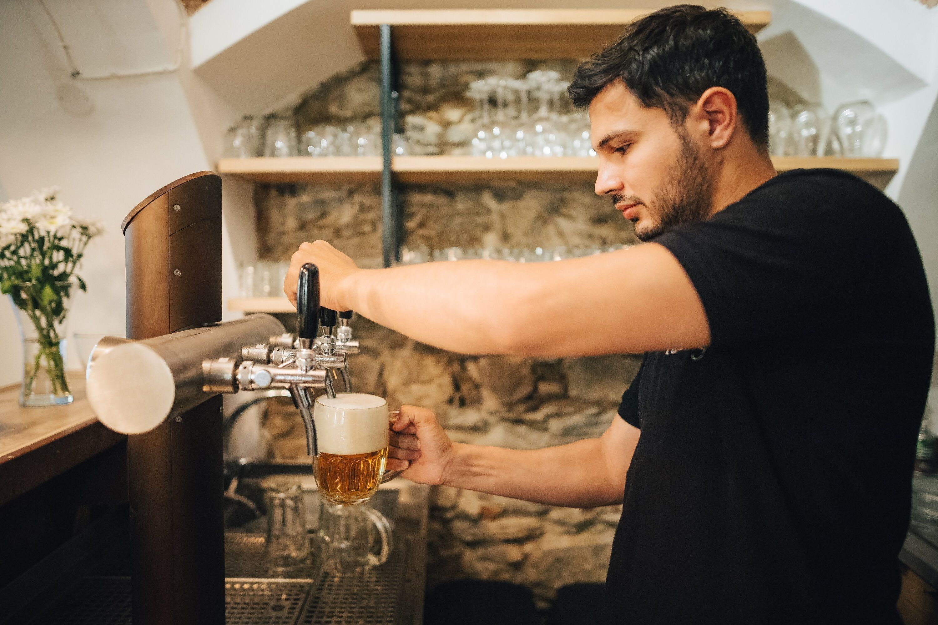 Iemand giet bier van een tappunt in een glas.