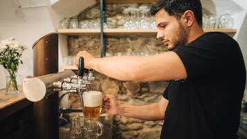 A person pouring beer from a tap into a glass.