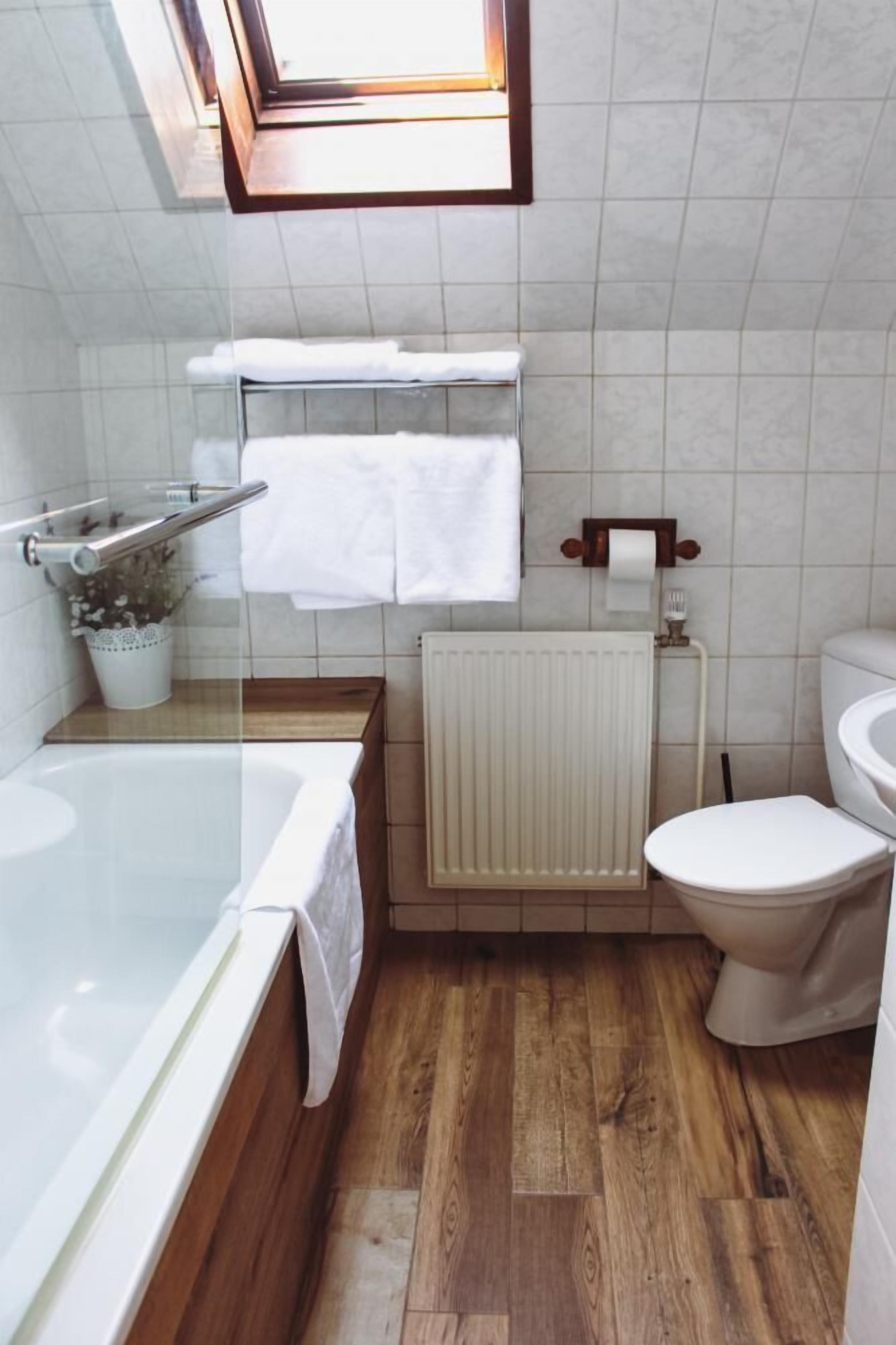 Un baño con bañera, inodoro y radiador.