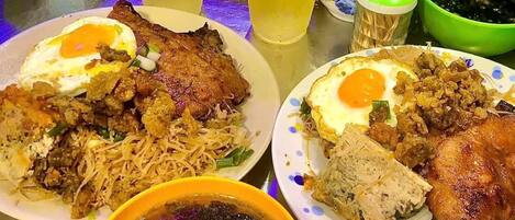 Una mesa con dos platos de comida, dos bebidas y un tazón de sopa.