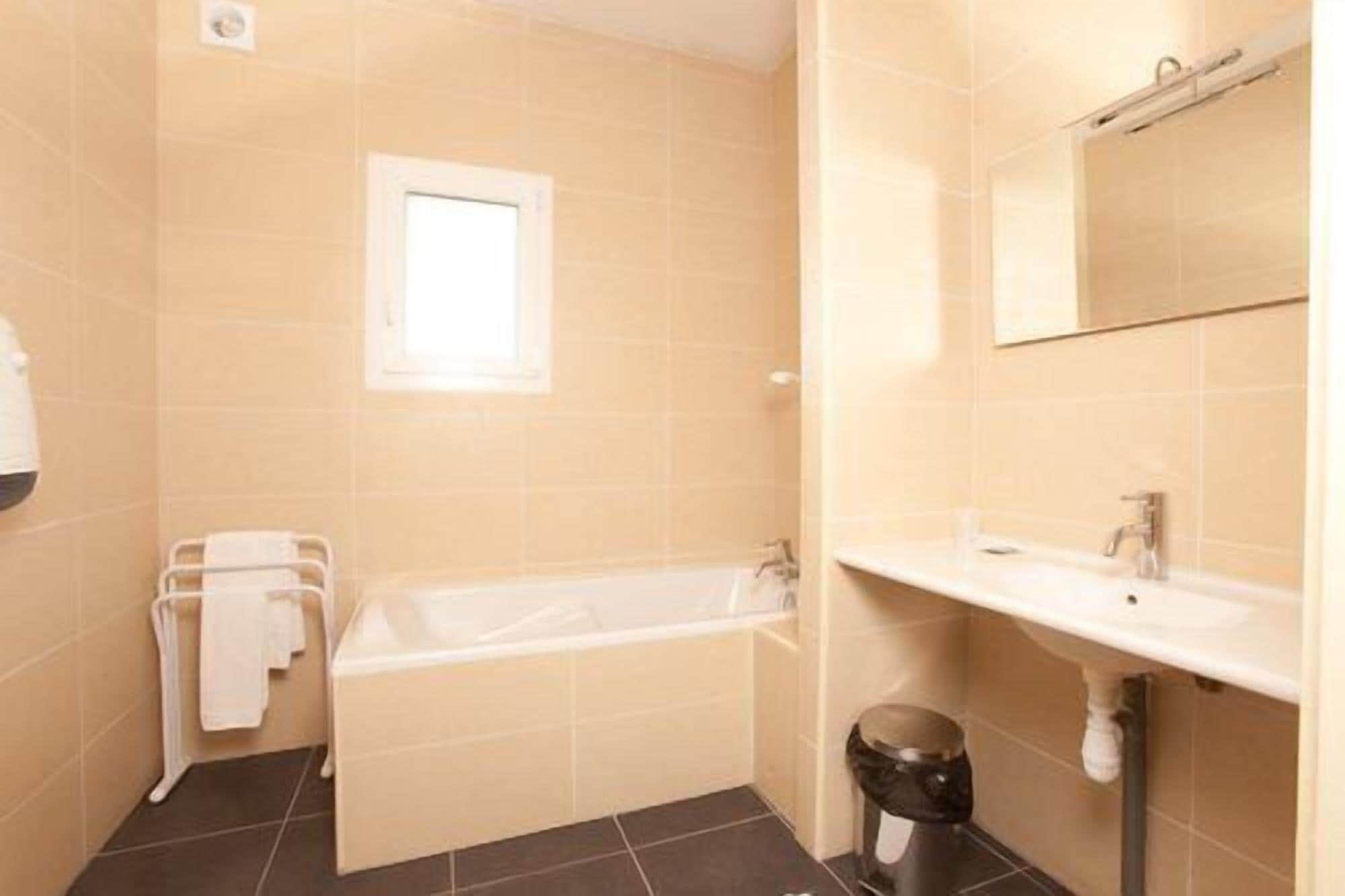 Un baño con bañera, lavamanos y espejo.