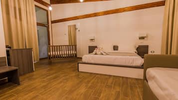 Un dormitorio con suelo de madera, cama con ropa blanca, mesita de noche, escritorio y una silla.