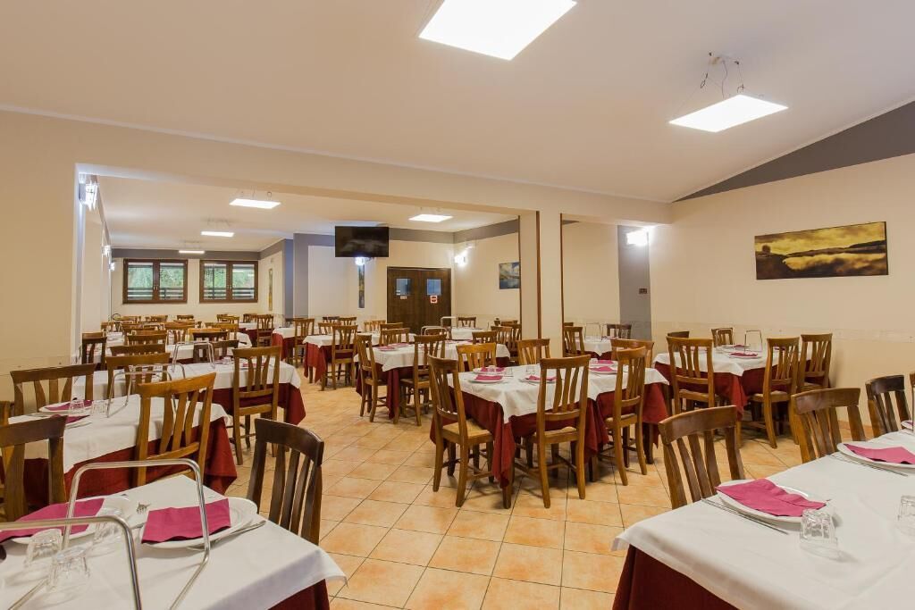 Un amplio comedor con numerosas mesas y sillas dispuestas en filas.