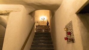 A staircase with a wooden handrail leading to a landing with a vase and a candelabra. - Chambre D'Hôtes La Marlotte (Castello-di-Rostino)