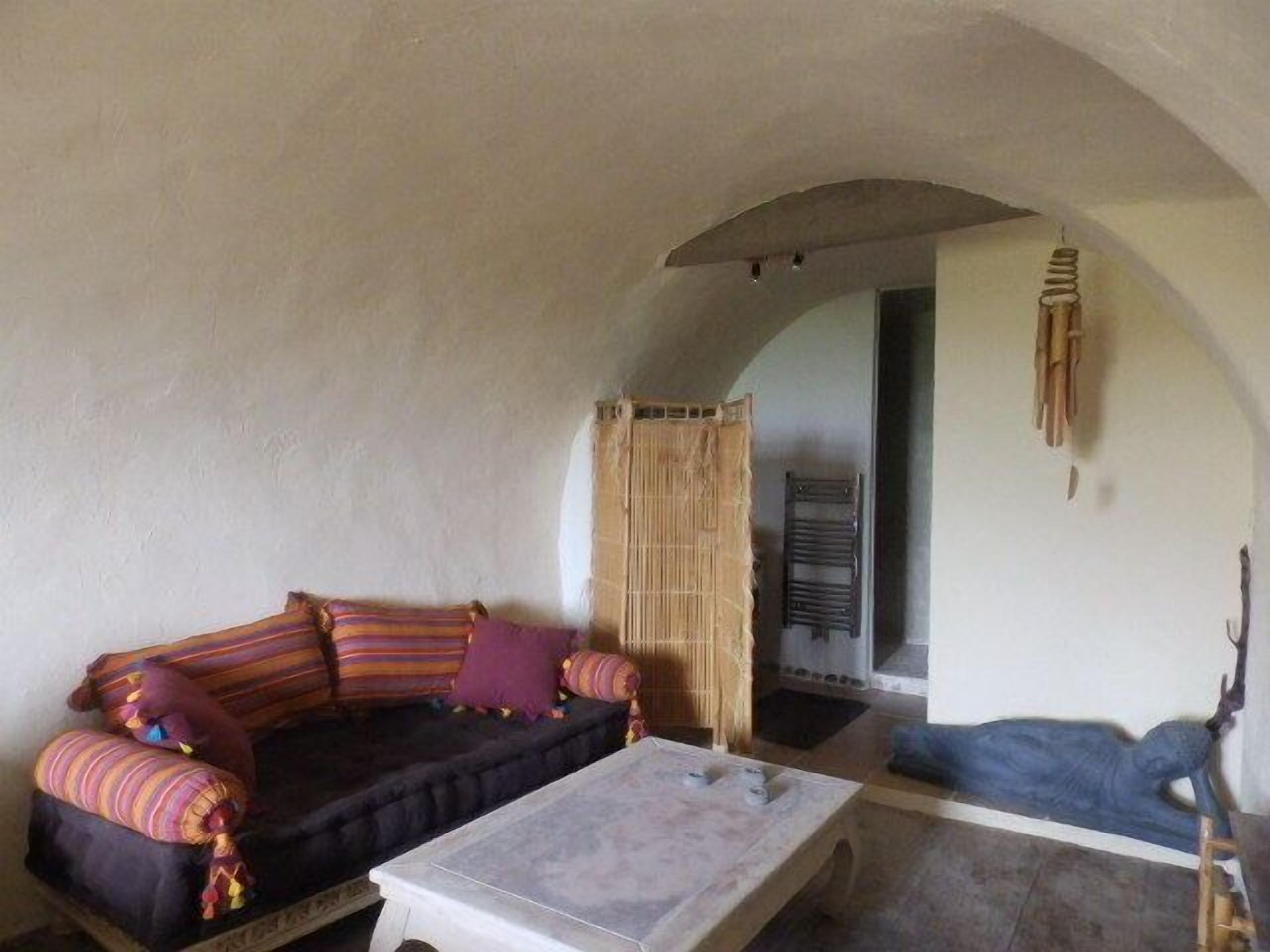 A cozy living room with a sofa, a coffee table, and a decorative sculpture.