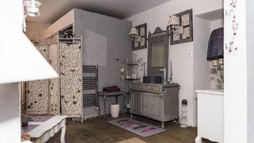 Une pièce de taille modeste, dotée d’une armoire intégrée, d’une coiffeuse avec miroir et d’une petite table.