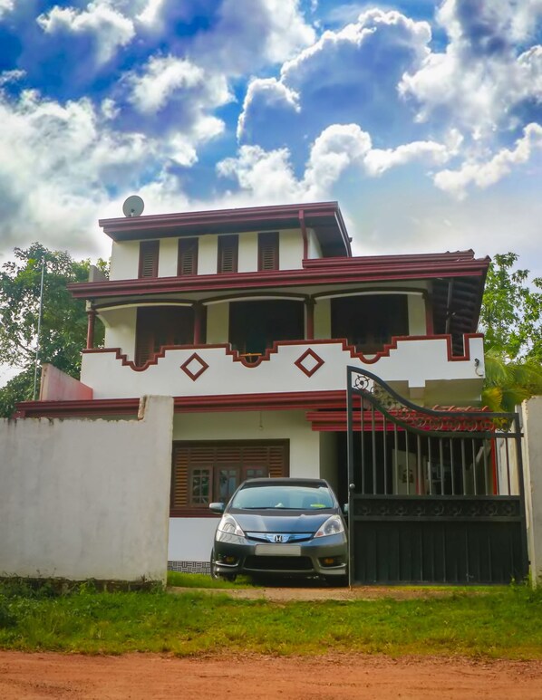 A two-story house with a car parked in front.