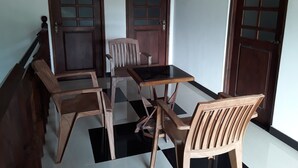 A dining area with a checkered floor, wooden furniture, and two doors with glass panels. - Darshani Hikka Villa (Hikkaduwa)